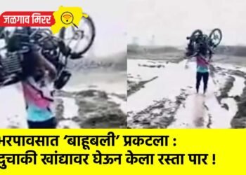 भरपावसात ‘बाहूबली’ प्रकटला : दुचाकी खांद्यावर घेऊन केला रस्ता पार !